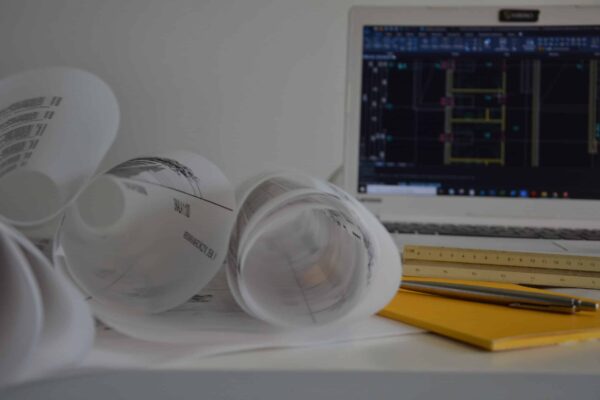 Projekt budowlany, projekt gotowy, komputer, sterta papierów.